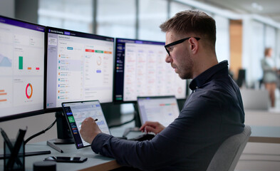 Fototapeta premium Man Reviews Financial Sanctions Alerts On Laptop