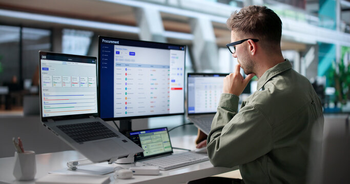 Man Uses Laptop To Review Supplier Contracts