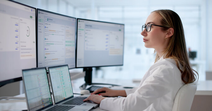 Young Female Medical Scribe Reviews Clinical Notes On Laptop