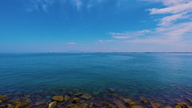 Scenic view of the Strait of Malacca from Penang Island with ships and rocky coastline
