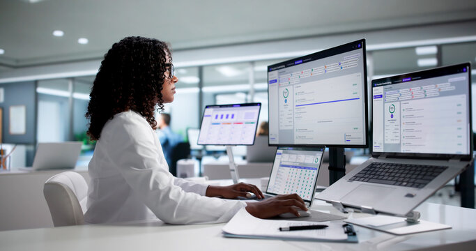 Woman Doctor Managing Medical Licensing Data Efficiently On Laptop