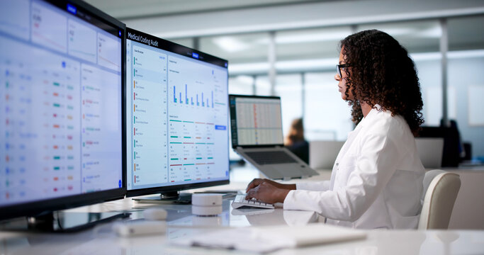 Young African Woman Reviewing Medical Files On Computer