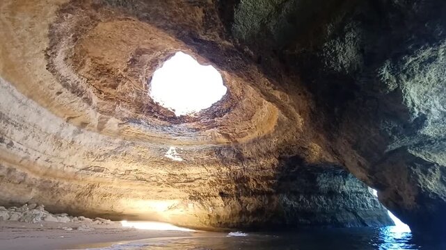 Interior view of Benagil sea cave with a natural sunbeam dome opening in Algarve
