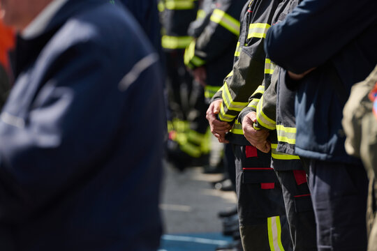 Firefighters Standing in Formation With Hands Clasped During Memorial or Ceremony