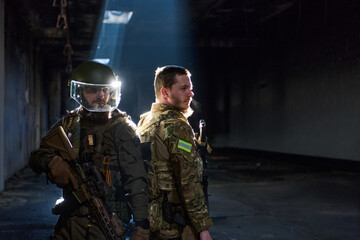 Obraz premium Two Tactical Soldiers Back-to-Back in Urban Ruin With Rifles and Protective Gear