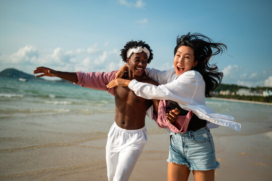 Stylish young multiethnic people in trendy summer outfits enjoying a sunny day at a beach resort