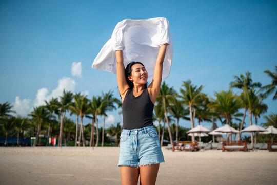 Trendy young traveler enjoying sunny weather and coastal breeze on a luxury tropical island resort