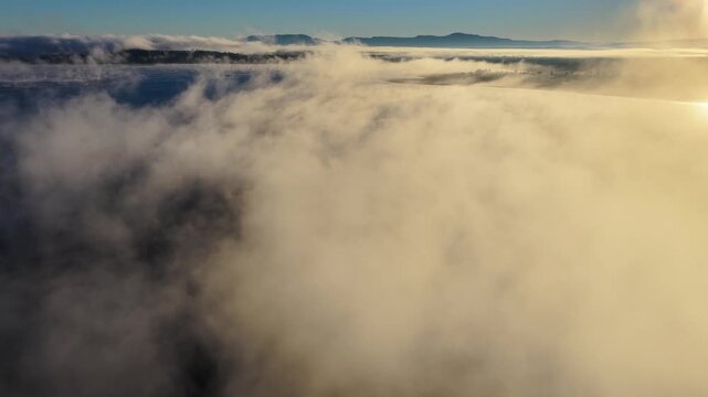 Aerial video of Lake Keepit Dam blanketed by morning fog in NSW, Australia. Low cloud drifts across the reservoir and surrounding landscape