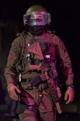 Obraz premium Tactical Soldier in Full Gear With Helmet, Shield Visor and Assault Rifle at Night Patrol