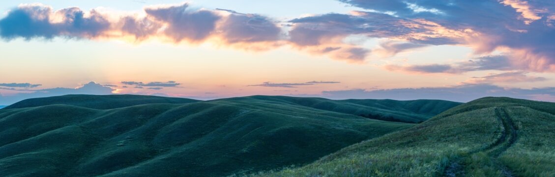 Summer sunset at Hills in the Orenburg region, Russia. Hilly terrain, mountain fields. The beginning of the Ural Mountains. The Dolgiye Mountains.
