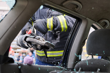 Fototapeta premium Firefighter Using Hydraulic Spreader (Jaws of Life) During Vehicle Extrication Through Car Window