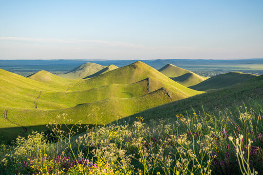 Summer sunny day at Dolgiye Mountains in the Orenburg region, Russia. Hilly terrain, mountain fields. The beginning of the Ural Mountains.