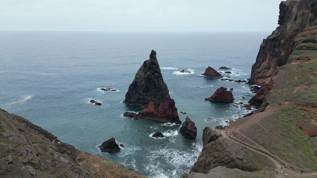 Drone aerial push forward shot of majestic volcanic rock formations in Madeira ocean, Ponta de Sao Lourenco