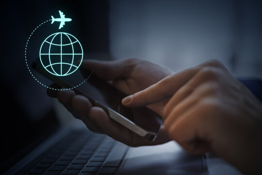 Person using smartphone with glowing airplane and globe interface for digital travel planning and worldwide connectivity concept on dark background.