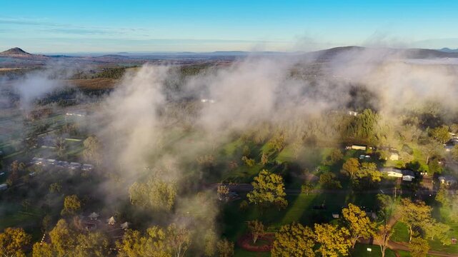 Aerial video of Lake Keepit Dam blanketed by morning fog in NSW, Australia. Low cloud drifts across the reservoir and surrounding landscape