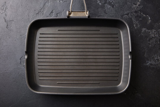 Empty grill pan on black textured stone background top view. Close up. Top view.