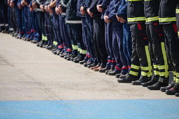 Obraz premium Line Of Firefighters And Emergency Crew Standing In Uniforms During Ceremony Or Drill