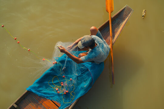 Fishing activity in Surat Thani Thailand on a calm river in a traditional boat