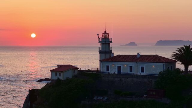 Cudillero lighthouse at sunrise aerial view, famous fishing village in Asturias, scenic lighthouse on a rock on the Atlantic coast of Spain, travel and adventure concept