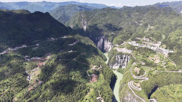 Cinematic aerial drone footage panning over expansive green valleys, winding rivers, and traditional rural villages in the scenic outskirts of Hefei, China &ndash; 2026