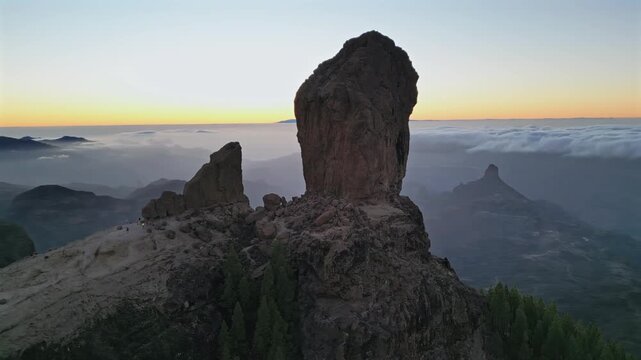 Stunning aerial footage showing Roque Nublo monolith and Roque Bentayga in Gran Canaria during a colorful sunset with a sea of clouds
