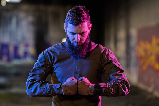 Bearded Man Wearing Tactical Jacket And Gloves In Moody Urban Portrait With Neon Lighting