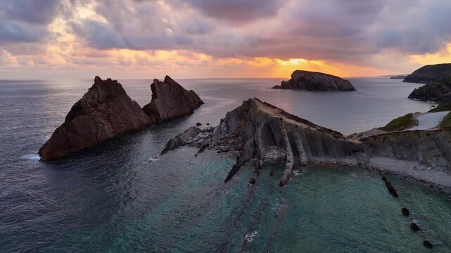 Cantabria rocky Atlantic coast at dawn, Spain, orbiting drone shot of Arnia beach in Dunas de Liencres natural park, scenic nature, rocky coast of Cantabria, travel in northern Spain