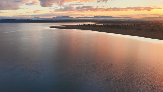 Aerial video flying over Lake Keepit Dam and the surrounding landscape in NSW, Australia. The expansive reservoir, dam wall and rolling countryside