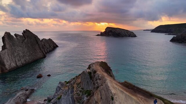 flying above scenic rocks on the beach off the Atlantic coast of Cantabria, northern Spain, Arnia beach near Santander at sunrise, drone view, ocean wilderness, beautiful cliffs on Cantabric coast