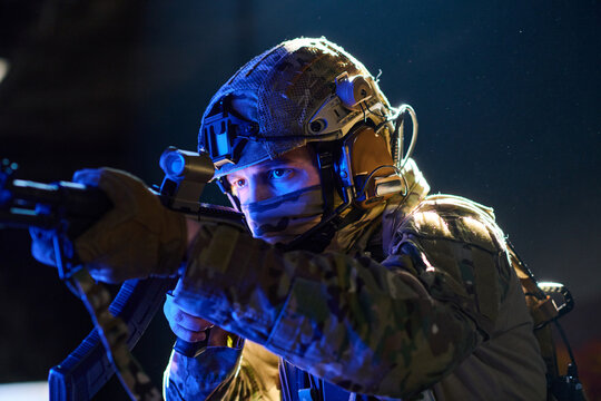 Special Forces Soldier Aiming Rifle During Night Tactical Operation With Helmet And Comms Gear