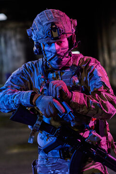 Tactical Soldier in Camouflage Gear Holding Rifle During Night Military Operation With Helmet and Mask