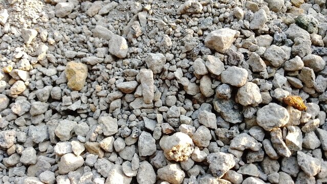 Close-up of gravel and small stones on rocky ground. Textured natural surface for landscaping or construction projects.