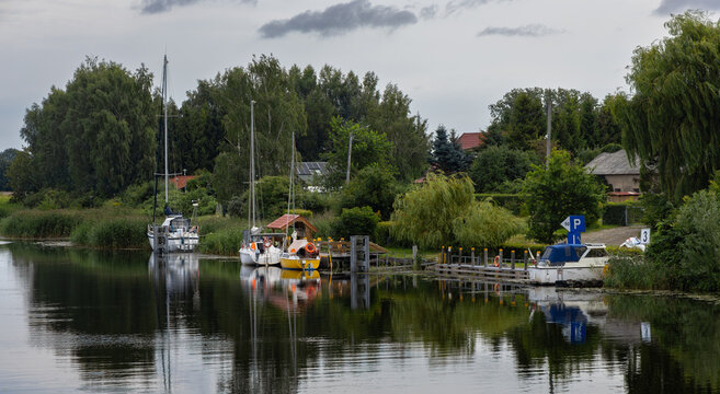 Sailboats and boats moored at a small marina on the Szkarpawa River.