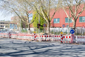Straßenbaustelle mit Absperrungen unter alten Stadtbäumen © GordonGrand