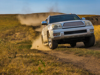 Silver SUV driving off-road on a dusty hillside © lucky pics