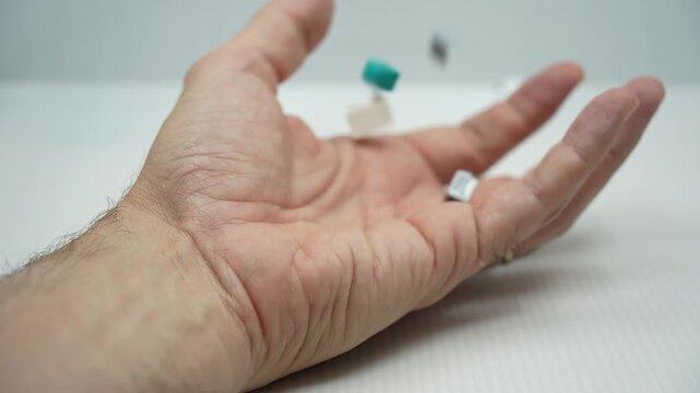 Small colorful toy building blocks falling into the open palm of a man's hand. Representing a collector's hobby. Nostalgia for childhood play. And the kidult phenomenon