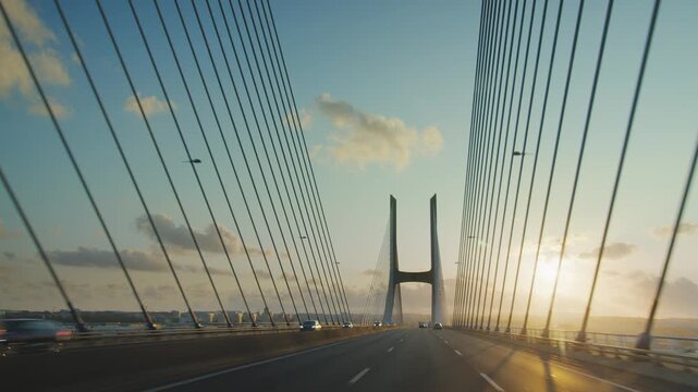Driving on Vasco da Gama cable stayed bridge at sunset view from car camera, Lisbon, Portugal. Longest bridge in Europe over Tagus river. 