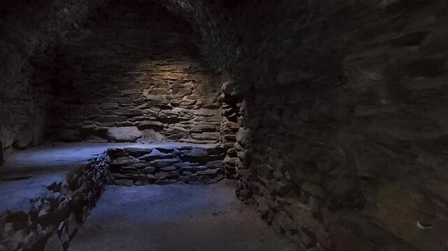Interior view of a stone chamber with ancient stone platforms inside Tash Rabat caravanserai in Kyrgyzstan. Masonry and the medieval architecture of the historic Silk Road monument.