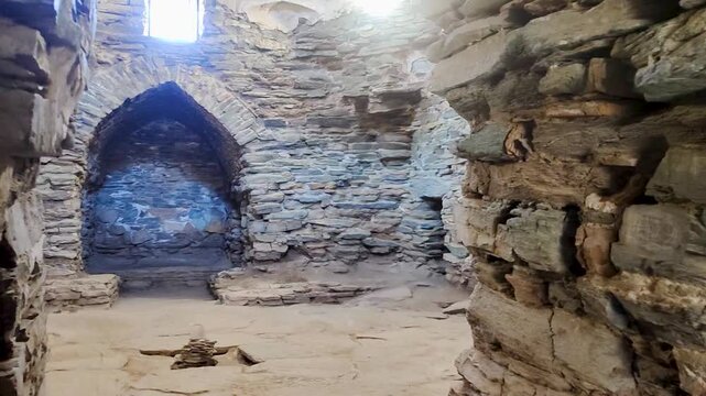 Interior walkthrough of the medieval Tash Rabat caravanserai in Kyrgyzstan. The camera moves through interconnected stone corridors and chambers. Authentic Silk Road architecture and historic masonry.