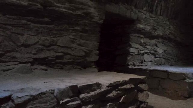 Interior view of a historic stone chamber inside the medieval Tash Rabat caravanserai in Kyrgyzstan. The room features massive masonry walls, stone platforms and authentic Silk Road architecture.