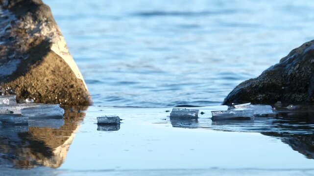 冬の湖岸に張る氷と穏やかな湖面