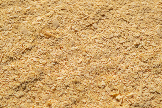 Close-up of nutritional yeast flakes texture on a flat surface, golden food seasoning background