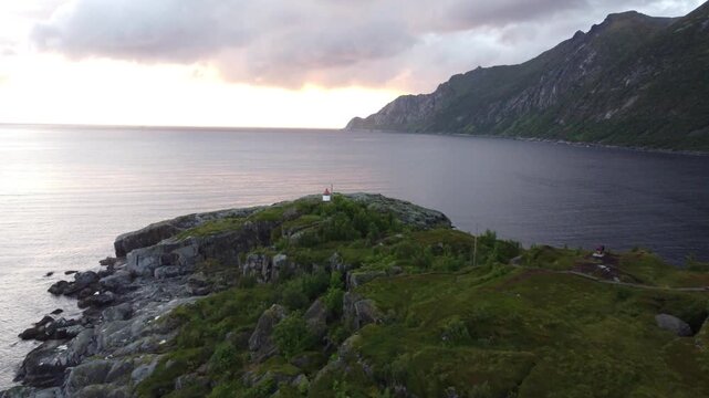 Golden hour drone shot of Husoy fishing village surrounded by arctic fjord