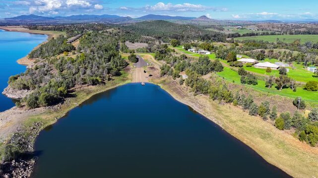 Aerial video flying over Lake Keepit Dam and the surrounding landscape in NSW, Australia. The expansive reservoir, dam wall and rolling countryside