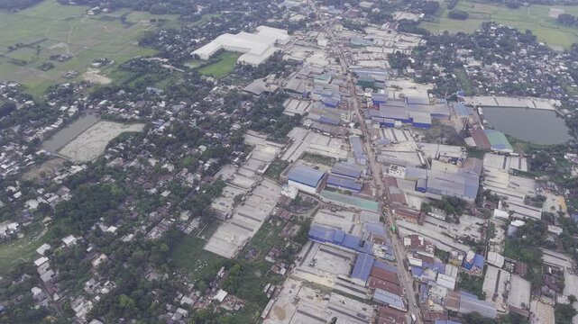 Aerial drone footage moving right across the Khajanagar industrial area in Kushtia, Bangladesh, showing factory buildings, roads, rooftops, and surrounding green landscape.
