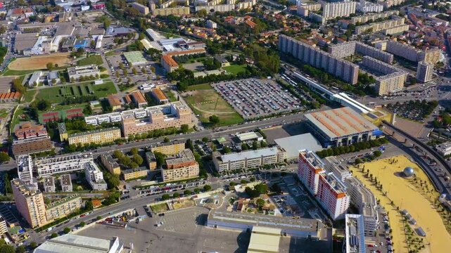 Aerial drone view of residential districts near Boulevard Michelet in Marseille with apartment blocks, Parc Chanot exhibition halls, parking lots and streets, France, in daytime.