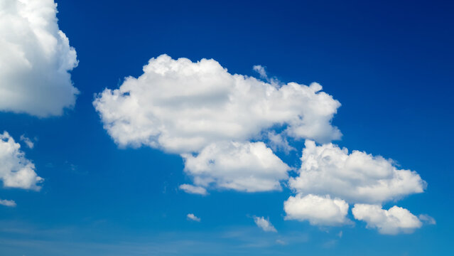 large cumulus cloud in the center of the sky with small cloud fragments around it