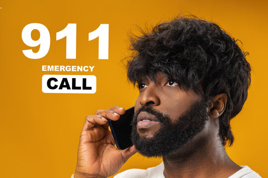 Person makes emergency 911 call for help on a smartphone in a bright room with yellow background and focused expression