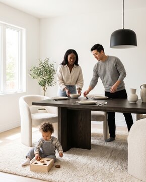 Toddler playing with wooden toys on the dining room floor while parents set the table, enjoying togetherness and happy moments in modern minimalist home interior