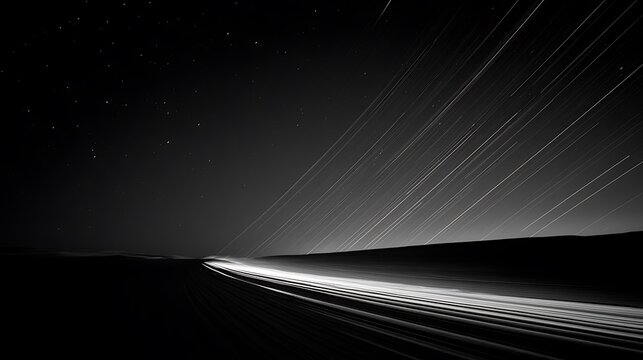 Long exposure night shot of car light trails on a dark highway road under a beautiful starry sky at night